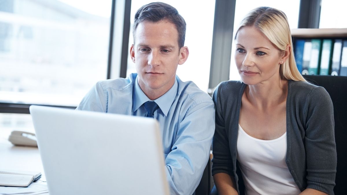 Man and woman reviewing information on a laptop, representing financial planning and Obamacare subsidies.