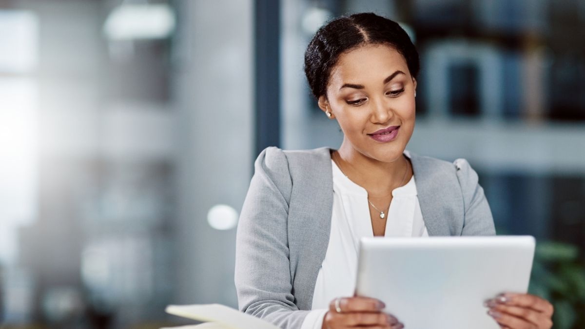 Professional woman reviewing financial documents on a tablet, symbolizing how a self directed HSA can enhance long-term savings.