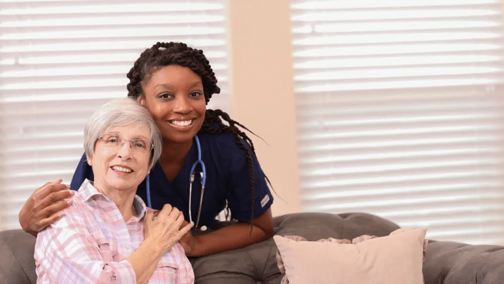 A smiling caregiver with an older woman