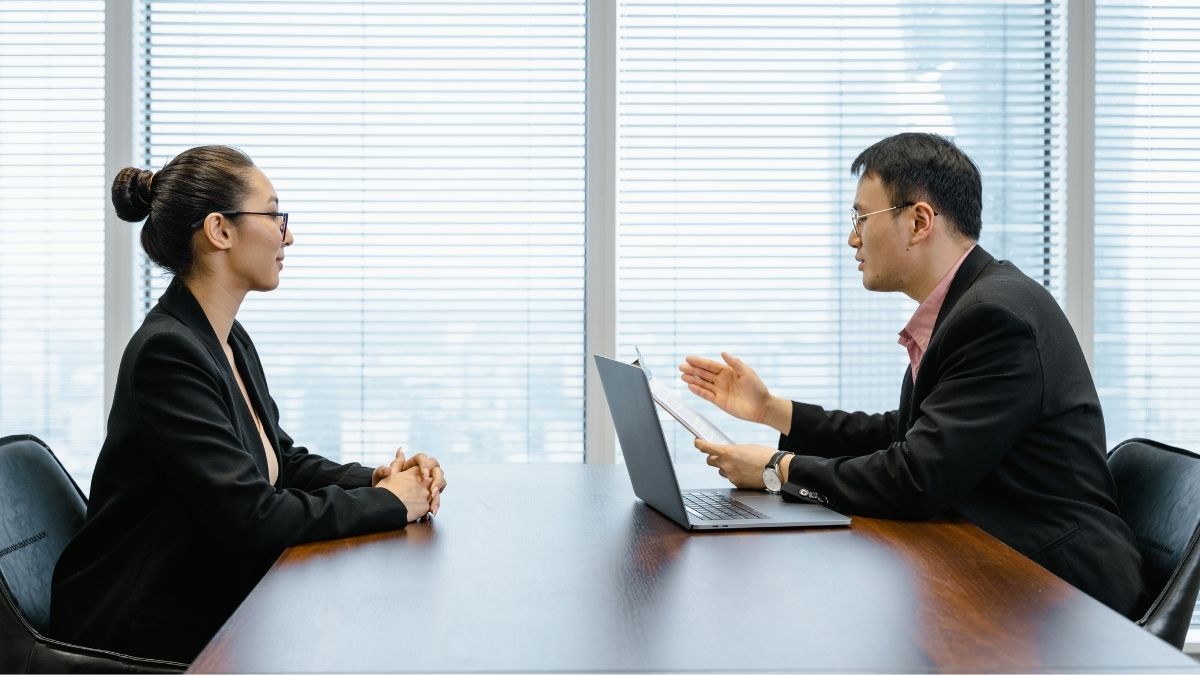 Two professionals in a serious discussion during a meeting, symbolizing concerns like “my employer offers health insurance but I can't afford it,” highlighting challenges employees face when benefits are out of financial reach.